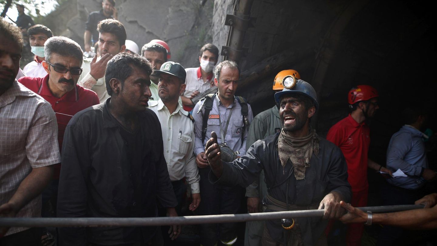 Iranische Bergarbeiter hoffen am Eingang des Bergwerks auf die Bergung der verschütteten Kumpel