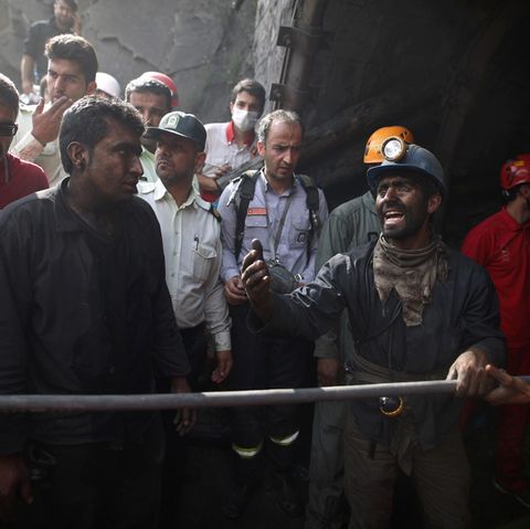 Iranische Bergarbeiter hoffen am Eingang des Bergwerks auf die Bergung der verschütteten Kumpel