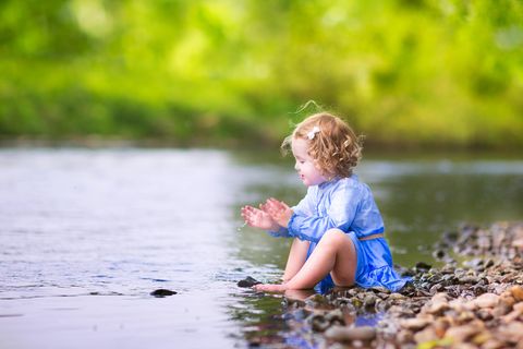 Ein kleines Mädchen sitzt am See