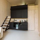 Unter dem "Hochbett" liegt die Küchenzeile. Dahinter Schränke und Bad.