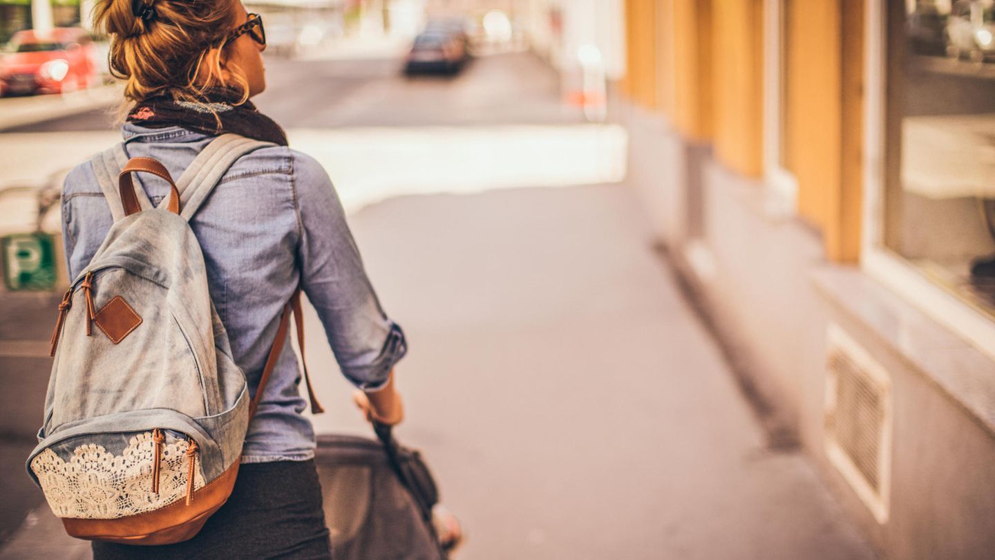 Mutter schiebt einen Kinderwagen