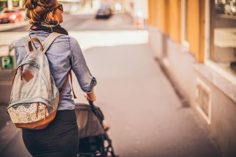 Mutter schiebt einen Kinderwagen