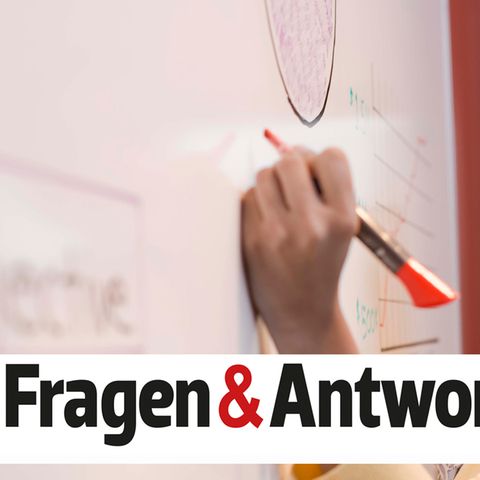 Eine Frau schreibt mit der linken Hand auf ein Flipchart