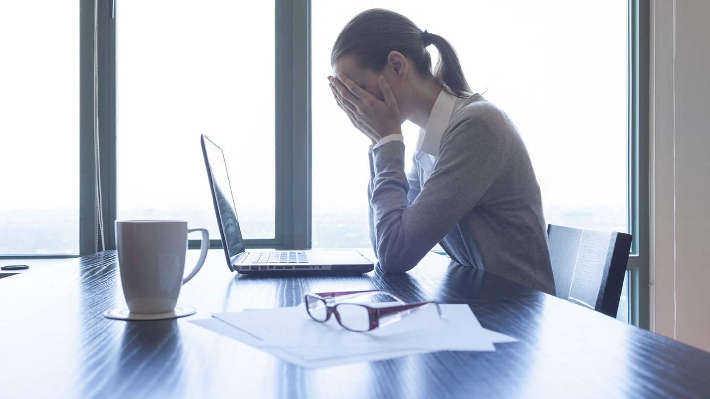Eine Frau schlägt vor dem Laptop die Hände vor dem Gesicht zusammen