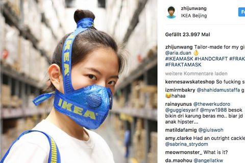 Eine junge chinesische Frau trägt einen aus einer Ikea-Tasche gefertigten Mundschutz