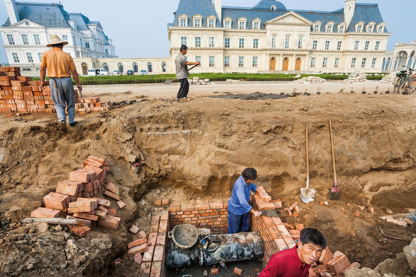 "Generation Wealth": Arbeiter beenden den Bau des Château Zhang Laffitte Hotels, eine Replik des französischen Château de Maisons-Laffitte in Peking im Jahr 2005. Für das Projekt wurden Hunderte Bauernfamilien umgesiedelt, um für den Neubau Platz zu machen. Sie können sich jetzt für Niedriglohnjobs bewerben, um das Anwesen zu pflegen. Arbeiter beenden den Bau des Château Zhang Laffitte Hotels, eine Replik des französischen Château de Maisons-Laffitte in Peking im Jahr 2005. Für das Projekt wurden Hunderte Bauernfamilien umgesiedelt, um für den Neubau Platz zu machen. Sie können sich jetzt für Niedriglohnjobs bewerben, um das Anwesen zu pflegen.