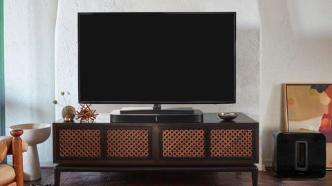 In einem schick eingerichteten Wohnzimmer steht ein Fernseher direkt auf der Sonos Playbar