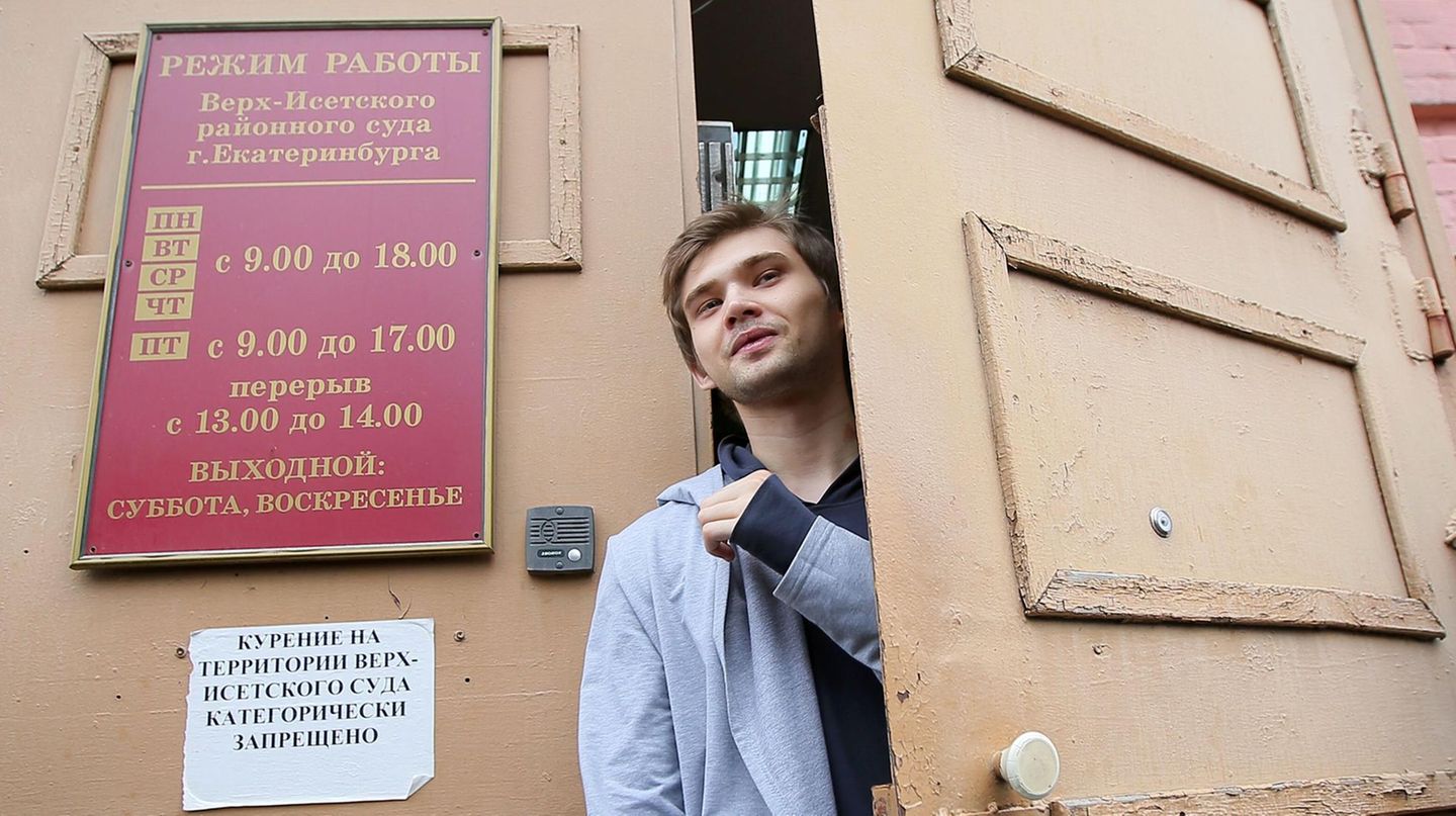Ruslan Sokolowski, ein junger Mann mit dunkelblonden Haaren und hellgrauer Jacke, schaut aus der Tür des Gerichtsgebäudes