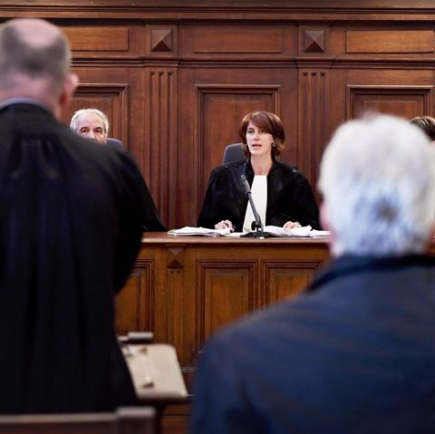 Eine Richterin in Robe sitzt auf der Richterbank aus dunklem Holz im Prozess wegen moderner Sklaverei in Brüssel