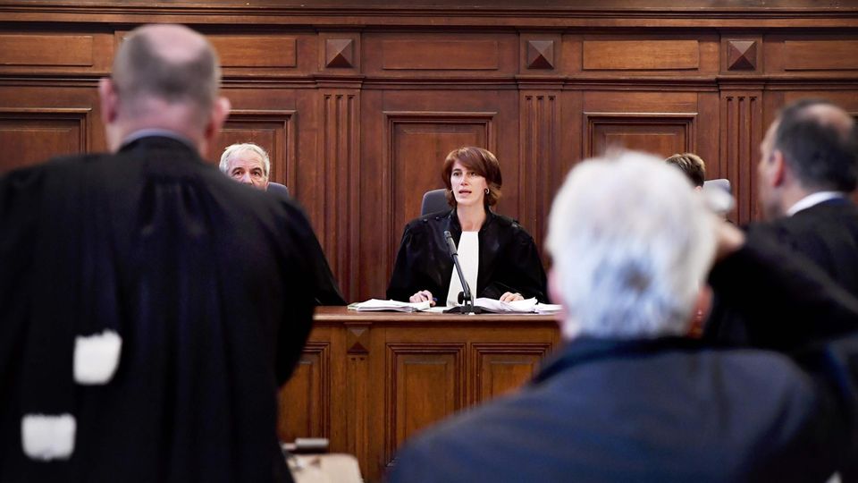 Eine Richterin in Robe sitzt auf der Richterbank aus dunklem Holz im Prozess wegen moderner Sklaverei in Brüssel