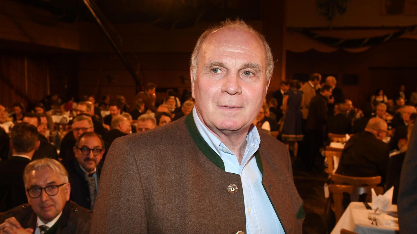Uli Hoeneß steht im Janker in einem dunklen Bierzelt