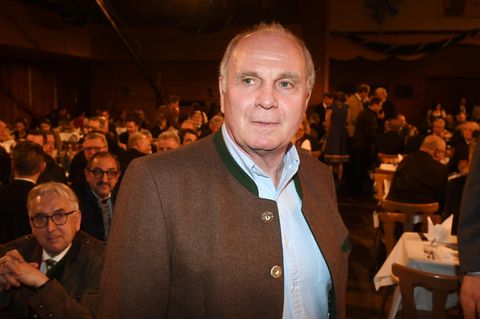 Uli Hoeneß steht im Janker in einem dunklen Bierzelt