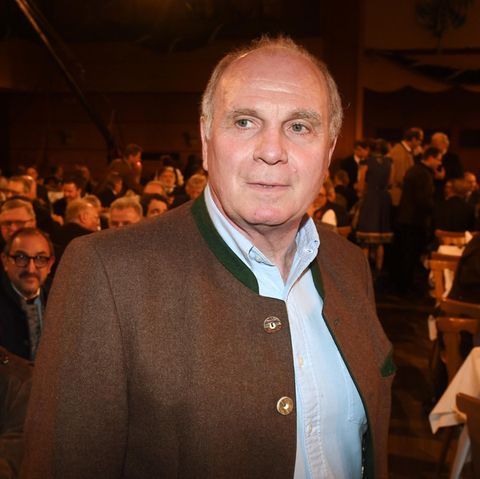 Uli Hoeneß steht im Janker in einem dunklen Bierzelt