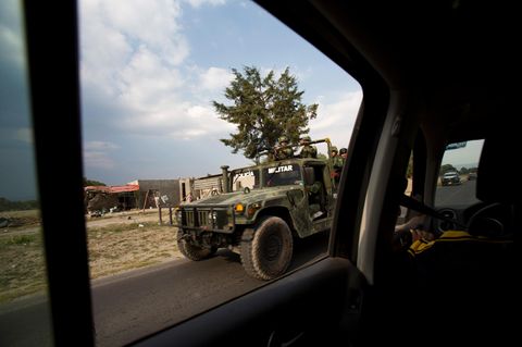 Durch das hintere Seitenfenster eines Autos ist ein Humvee des mexikanischen Militärs im Vorbeifahren zu sehen.