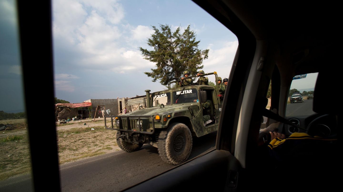 Durch das hintere Seitenfenster eines Autos ist ein Humvee des mexikanischen Militärs im Vorbeifahren zu sehen.