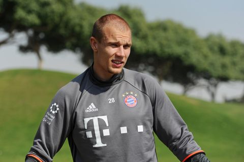 Im grauen Trainingspullover des FC Bayern München steht Holger Badstuber auf dem Platz und blinzelt in die Sonne.