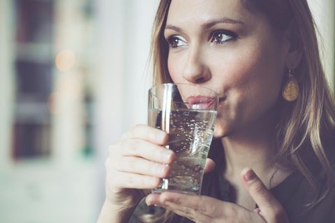 Frau trinkt Wasser mit Kohlensäure