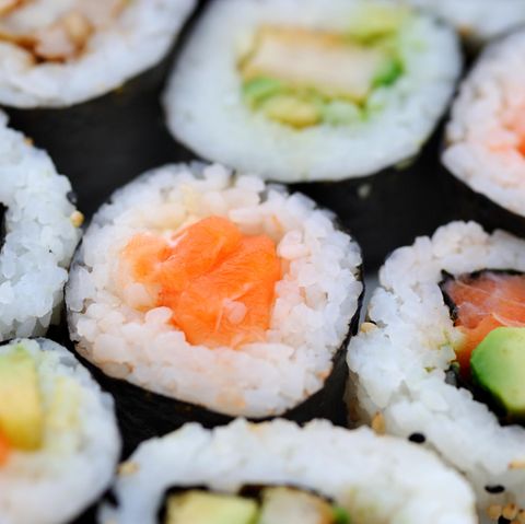 Sushi mit rohem Fisch liegt auf einem Teller.