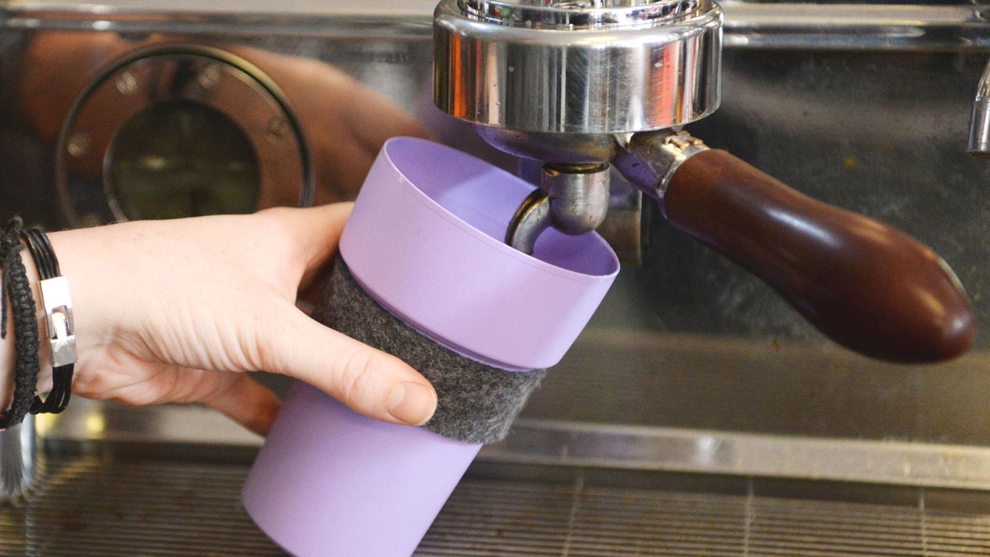 In einem Café wird ein Becher gefüllt
