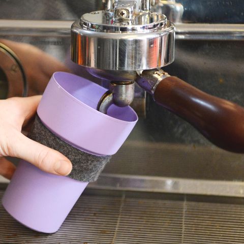 In einem Café wird ein Becher gefüllt