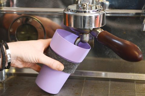 In einem Café wird ein Becher gefüllt