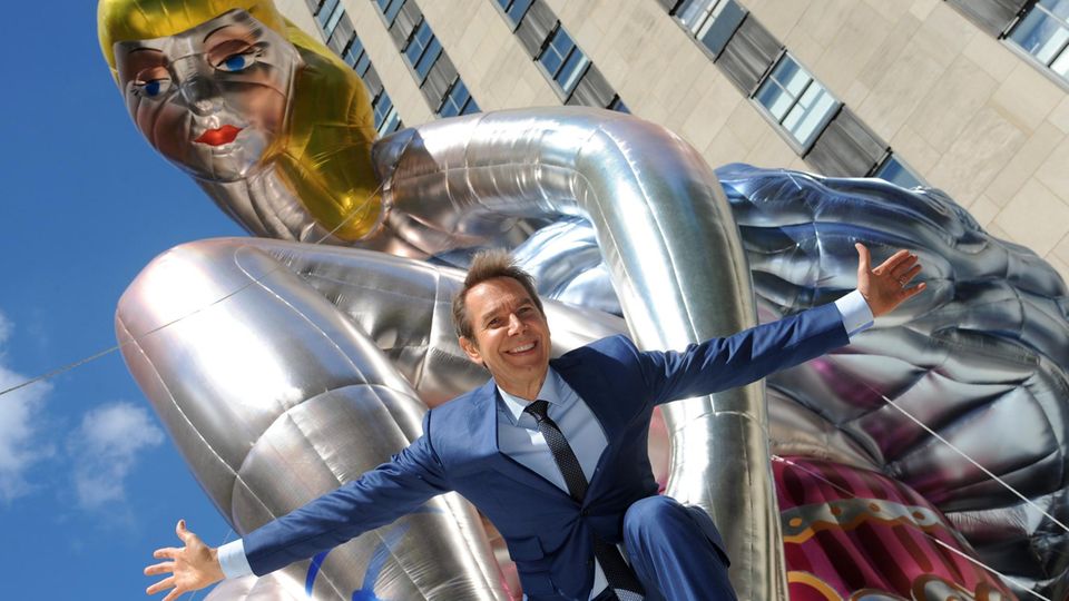 Jeff Koons "Seated Ballerina" Jeff Koons kniet vor seiner "Seated Ballerina" und lacht in die Kamera