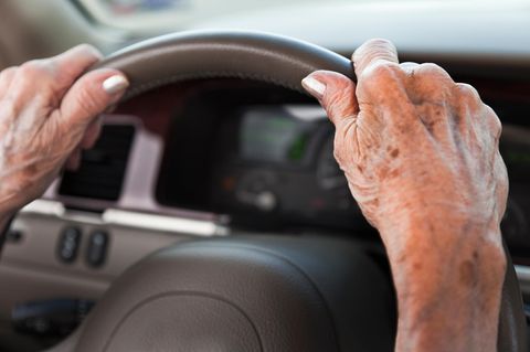 Hände einer alten Frau am Lenkrad eines Autos