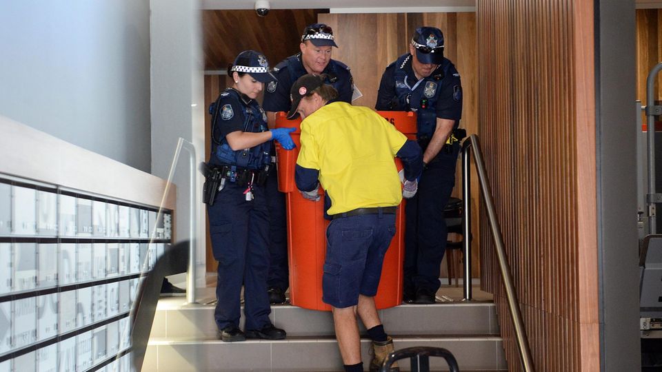 Polizisten bergen eine Mülltonne aus dem Wohnung Nr. 3 in einem Wohnhaus in Brisbane