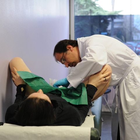 Ein Arzt untersucht die Vagina einer Frau