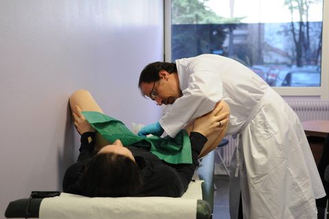 Ein Arzt untersucht die Vagina einer Frau