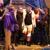 Ein verletzter Mann wird von Helfern vom Anschlagsort weggeführt