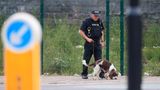 Ein Polizist sucht mit einem Spürhund die Umgebung der Arena ab