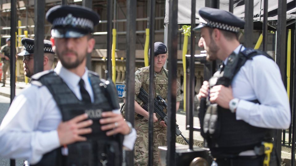 Soldaten und Polizisten bewachen die Downing Street in Westminster, London.