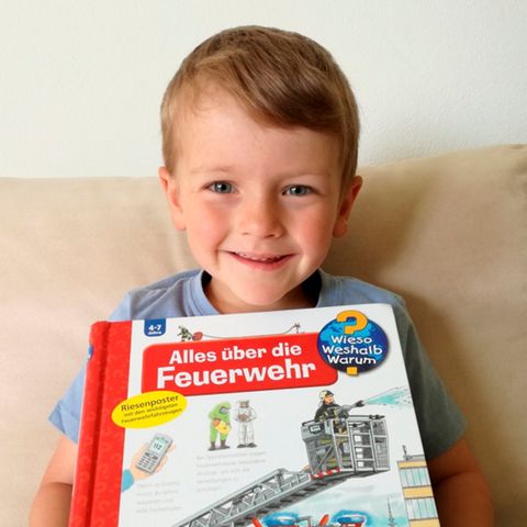 Der kleine Tobias zeigt strahlend sein Buch