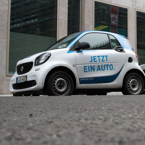 Zwei Car2Go Wagen stehen an einer Straße in Köln. Der Carsharing-Anbieter könnte bald mit Konkurrent DriveNow fusionieren.