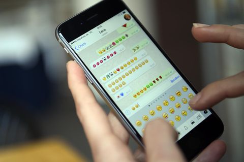 Ein Smartphone zeigt einen WhatsApp-Chat, in dem nur Emoticons hin und her versendet werden.