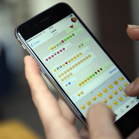 Ein Smartphone zeigt einen WhatsApp-Chat, in dem nur Emoticons hin und her versendet werden.