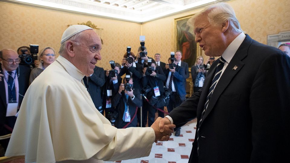 US-Präsident Donald Trump und Papst Franziskus schütteln sich im Vatikan die Hand. Im Hintergrund arbeiten Fotografen.