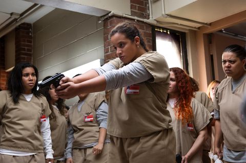 Ein Ausschnitt aus Orange is the New Black Staffel 5 zeigt Gefangene Darya mit Pistole