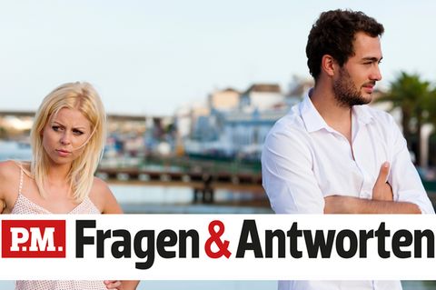 Ein Paar streitet im Urlaub vor Meereskulisse