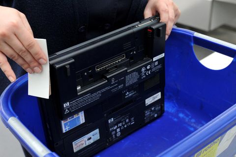 Ein Laptop in einem Plastikbehälter an der Sicherheitskontrolle am Flughafen