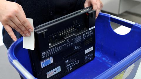 Ein Laptop in einem Plastikbehälter an der Sicherheitskontrolle am Flughafen