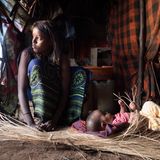 Bone Guyo Wario ist wegen ihrem Mann in den Ort Kalacha gezogen, beide leben dort trotzdem in einer Manyatta. Vor der Dürre hatte das Paar 45 Ziegen und  Schafe, heute nur noch sechs. Mit dem Knüpfen von Matten verdient die junge Mutter etwas dazu. "Mein Kind soll auf jeden Fall die Schule besuchen", sagt Bone, "wir müssen uns anpassen."