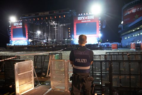 Polizeibeamte durchsuchen nach dem Festivalabbruch wegen Terrorgefahr das Gelände von Rock am Ring