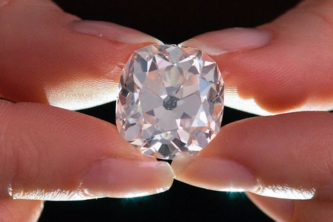 Ein Mitarbeiter des Auktionshauses Sotheby's hält zwischen Daumen und Zeigefingern einen Diamantring
