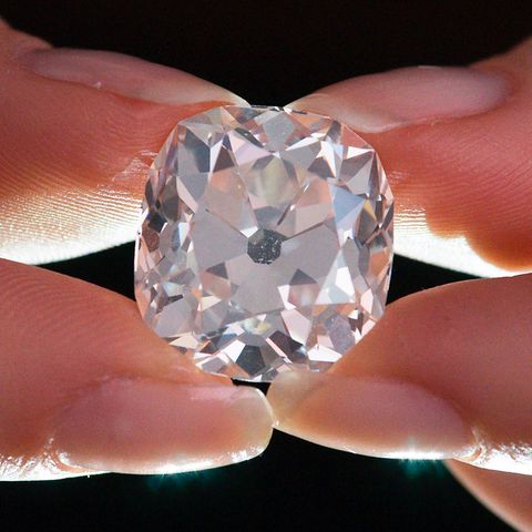 Ein Mitarbeiter des Auktionshauses Sotheby's hält zwischen Daumen und Zeigefingern einen Diamantring