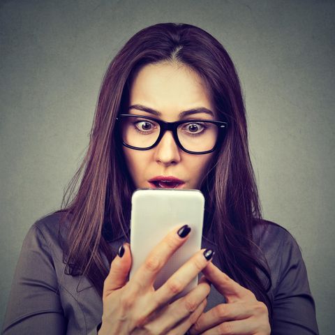 Ein Frau schaut entsetzt auf ihr Smartphone. Ob Facebook installiert ist, ist nicht zu sehen