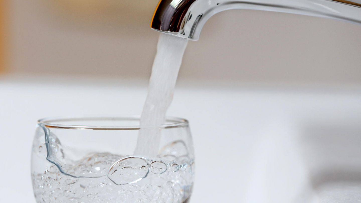 Trinkwasser fließt aus einem Wasserhahn in ein Glas