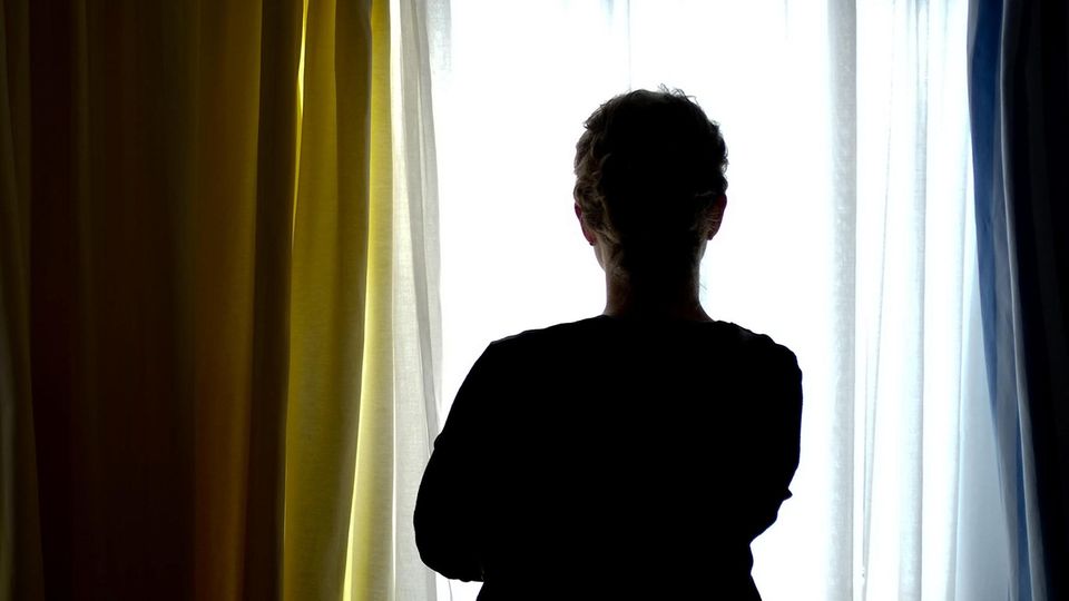 Eine Frau blickt aus dem Fenster (Symbolbild). Im Kampf gegen Depressionen setzen Krankenkassen auf Online-Therapien.