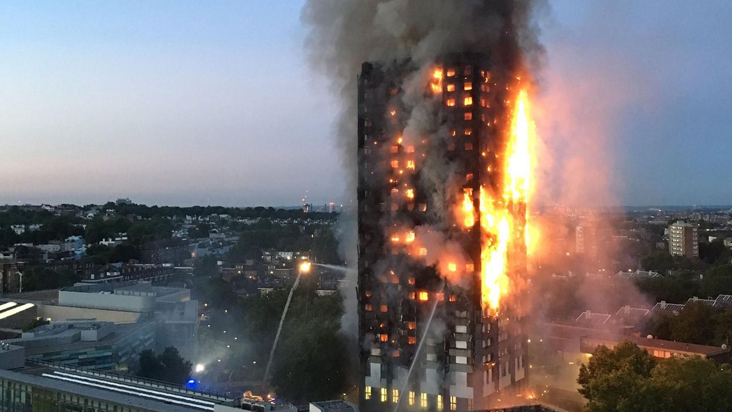 Ein Hochhaus in London brennt. Rechts schlagen Flammen über die gesamte Höhe aus der Fassade, links Feuerschein hinter Fenstern